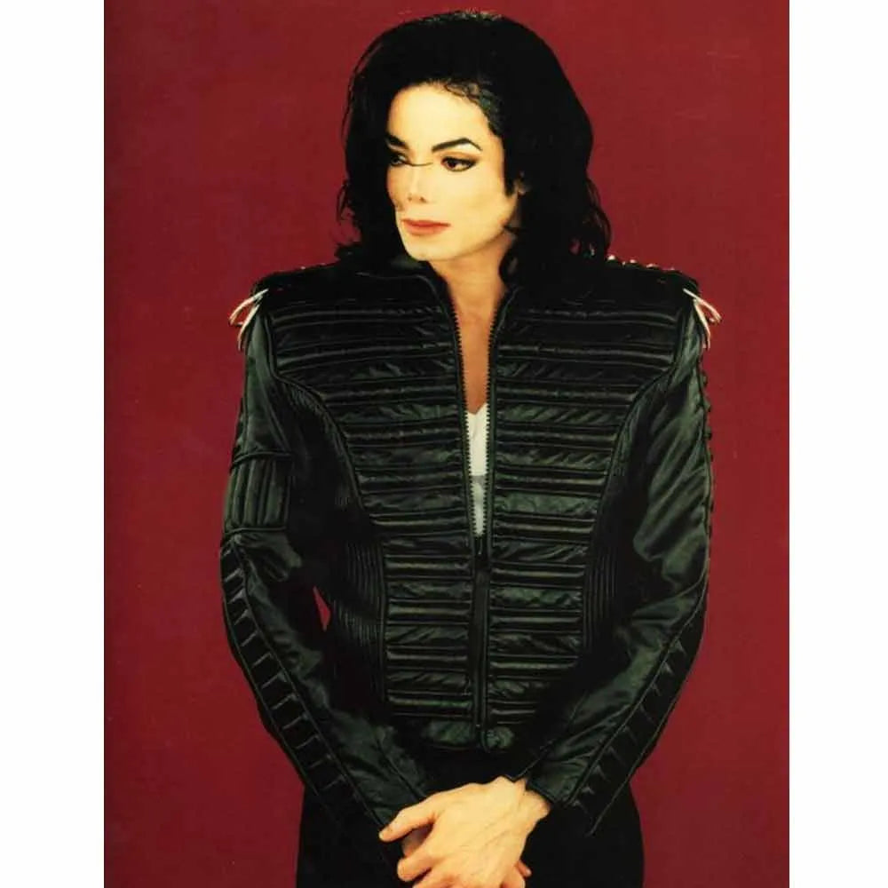Person wearing a black quilted jacket against a red 