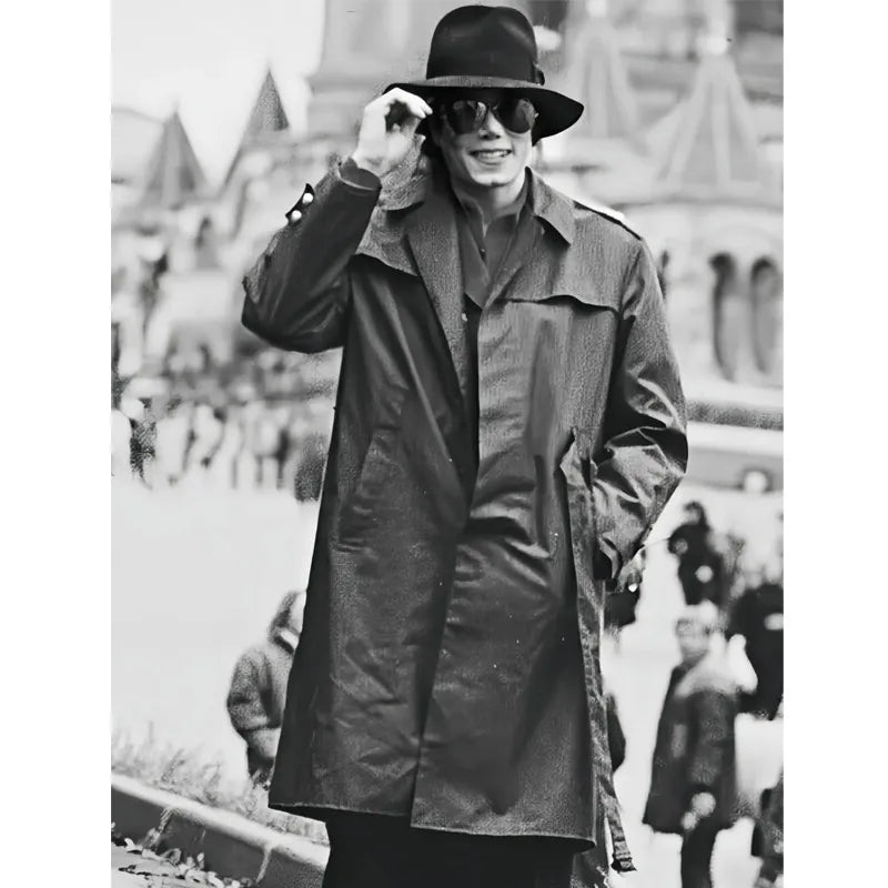 Person wearing a trench coat and hat in a black and white photo